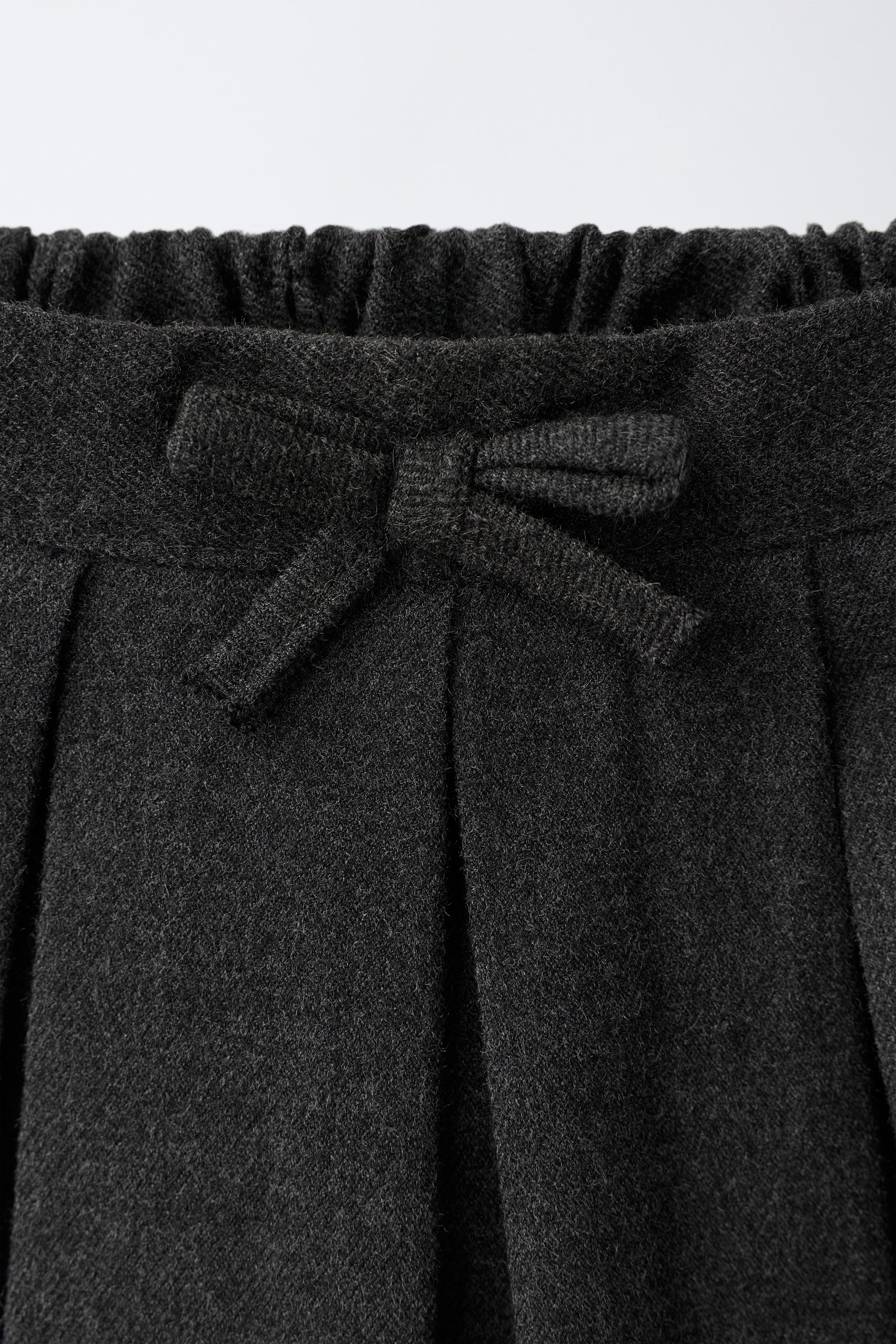PLEATED SKIRT WITH BOW APPLIQUÉ